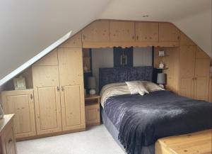 多尼戈尔Breezy Point Guesthouse的一间卧室设有一张床、木制橱柜和楼梯。