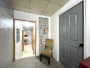 巴拿马城OyeBonita Hostel的走廊上,房间的门和椅子