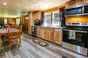 科斯比Rustic Cosby Cabin with Furnished Deck and Yard!的厨房配有桌子和炉灶。 顶部烤箱