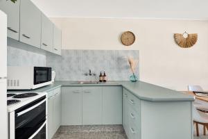 黄金海岸White Dolphin, Unit 7的白色的厨房配有水槽和微波炉