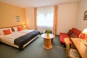 摩泽尔肯林格斯汀讷木勒兰德酒店的一间卧室配有一张床、一张桌子和一张沙发