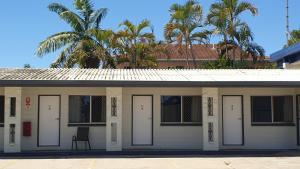 汤斯维尔Townsville City Motel的前方有白色门和椅子的建筑