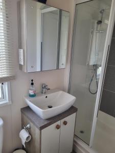 坎伯利Your Retreat Too的浴室配有白色水槽和淋浴。