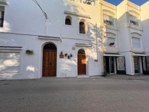 丹吉尔Riad Al-Qurtubi的街上的白色建筑,有棕色门