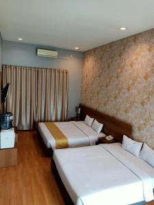 巴东Surya Palace Syariah的酒店客房设有两张床和窗户。