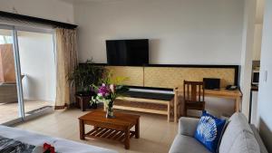 AmuriResort Tava'e的客厅配有沙发和墙上的电视