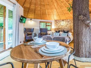 WadhurstBensfield Treehouse的用餐室配有带盘子和酒杯的桌子