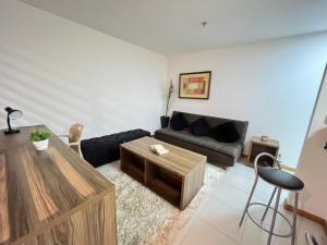 伊塔博拉伊Flat moderno com piscina e academia的带沙发和咖啡桌的客厅