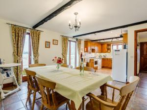Runcton Holme普尔林巴恩度假屋的厨房以及带桌椅的用餐室。