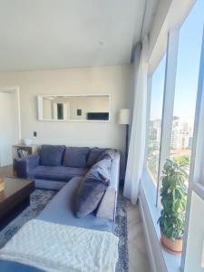 约翰内斯堡Spacious 2BR APT Near Sandton City -No Loadshedding的客厅设有蓝色的沙发和窗户。