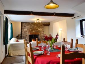 克里克豪厄尔Dardy Cottage的一间带桌子和壁炉的用餐室