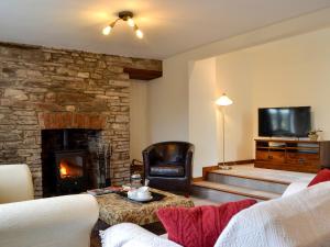 克里克豪厄尔Dardy Cottage的客厅设有壁炉和电视。