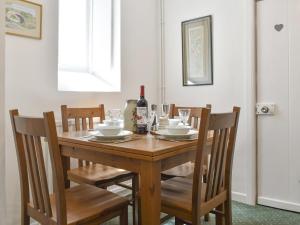 安赛德Underhill Cottage的一张带椅子的木桌和一瓶葡萄酒