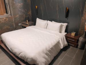 阿克拉Sky Suites East Legon的一张配有白色床单和枕头的大床