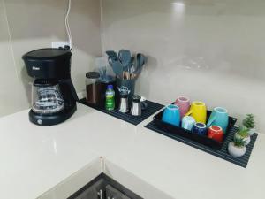 波帕扬Apartamento en centro de Popayán的厨房柜台配有两个带杯子的书架和咖啡壶