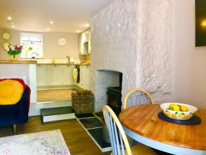BickingtonLemon Cottage的厨房以及带桌子和壁炉的客厅。
