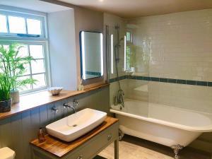 BickingtonLemon Cottage的带浴缸、水槽和浴缸的浴室