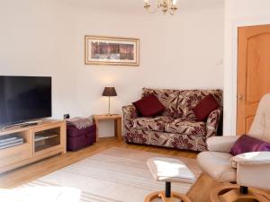 灵伍德Alices Lodge的带沙发和平面电视的客厅