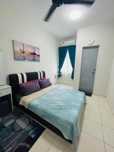 马六甲Insyirah Homestay Melaka的一间卧室配有一张带蓝色棉被的床