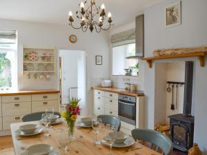 WhitwellElm Cottage的厨房配有桌椅和吊灯。
