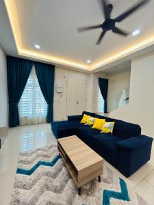 马六甲Insyirah Homestay Melaka的客厅配有蓝色的沙发和吊扇