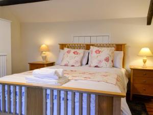 克里克豪厄尔Dardy Cottage的一间卧室配有一张带木制床头板和枕头的床。