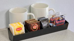 格伦因尼斯CBD GI Motel的托盘,包括两个咖啡杯和一些小吃