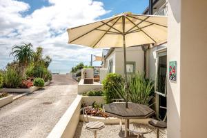 欧尼坦基旺唐伊海滩公寓的庭院配有遮阳伞和桌椅。