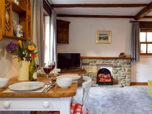 斯基普顿Mallards Nest的客厅配有桌子和壁炉