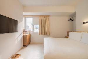 高雄瘾室 Inns Hotel的卧室设有一张白色大床和一扇窗户。