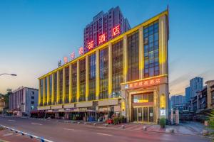 石柱寰宇君荟酒店(石柱汽车总站店)的一座黄色的大建筑,上面有红色的标志