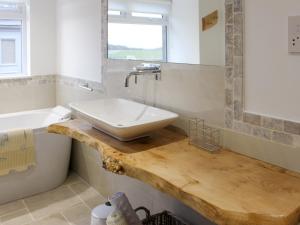 GortinananeRhunahaorine Cottage的木制柜台上带水槽的浴室