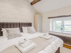 AshoverAlton Hall Cottage的卧室配有带毛巾的大型白色床