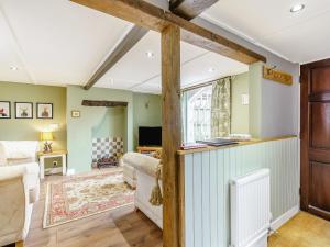 灵伍德Duck Island Cottage的客厅设有绿色的墙壁和木梁。