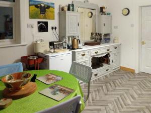 HowmoreAltabrug的厨房配有绿桌和炉灶。