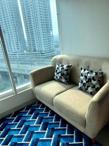 Pekayon SatuGrand Kamala Lagoon Bekasi Apartement的一张沙发,位于带大窗户的房间里
