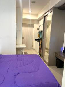 Pekayon SatuGrand Kamala Lagoon Bekasi Apartement的衣柜间里一张大紫色的床