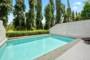 卡图The Fairways Villas - 5 bedrooms & bathroom for up to 14 guests 7kms to Patong的一座树木繁茂的房屋后院的游泳池