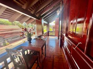 琅勃拉邦Lakhang Thong Hotel的一间设有桌子和花瓶的用餐室
