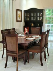 罗阿坦Spacious & Spotless new house, 4 BRs的餐桌、椅子、桌子和壁炉