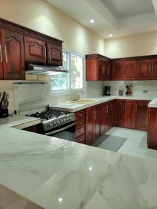罗阿坦Spacious & Spotless new house, 4 BRs的厨房配有木制橱柜和炉灶烤箱。
