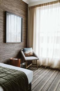 新普利茅斯斯塔特酒店的酒店客房设有椅子和窗户。