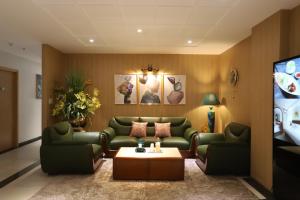 胡志明市Lanura Apartments and Hotel的客厅配有绿色沙发和电视