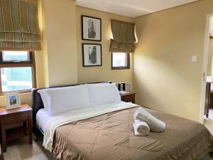 大雅台Crosswinds Resort One Bedroom Condo Suite的一间卧室配有带毛巾的床