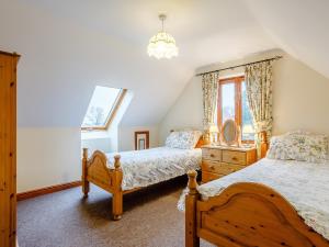 Runcton HolmeGable Barn - E3865的一间卧室设有两张床和窗户。