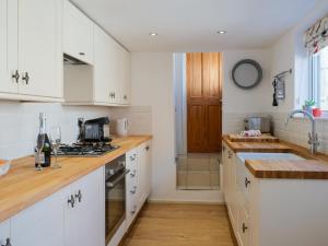 淡水洛雷托乡村别墅的厨房配有白色橱柜和木制台面