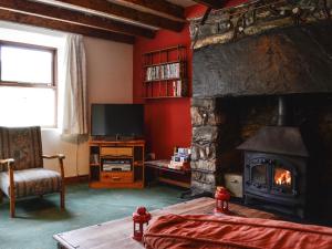 PenmachnoValley Cottage的客厅设有壁炉和电视。