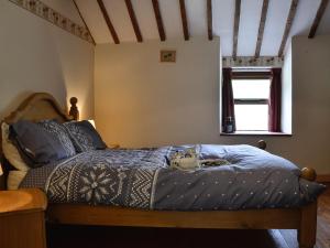 PenmachnoValley Cottage的一间卧室配有一张带蓝色棉被的床