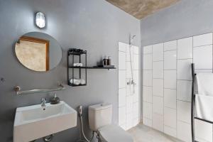 坎古Ambara U6 Loft by Hombali的一间带卫生间、水槽和镜子的浴室