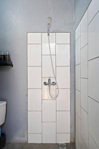 坎古Ambara U6 Loft by Hombali的浴室铺有白色瓷砖,设有淋浴。